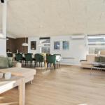 Living and dining area with light sofas, green chairs, and wooden floor.