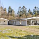 Modern holiday home with terrace and lawn. Surrounded by trees and grass area.