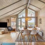 Living and dining area with wood paneling, dining table, TV, and wood stove.