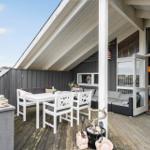 Deck with table, chairs, and seating. Entrance to interior furnishings.