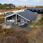Modern wooden cabin with terrace and sun loungers. View of open land.