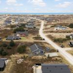 Village with houses between dunes and sea
