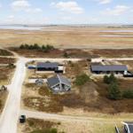 Aerial view of modern cabins near a wide water body.