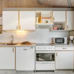Kitchen with white cabinets, sink, stove, and refrigerator.