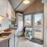 Kitchen with sink, refrigerator, and window to terrace.