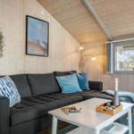 A living room with a gray sofa, white table, and wooden walls.