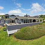 A house with terrace and garden under a blue sky.