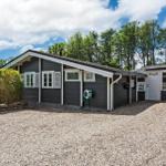 A dark gray house with white window frames and a garden door. A gravel area lies in front of the house.