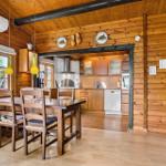 Dining area with wooden table and chairs. Kitchen with wooden cabinets and stainless steel appliances.