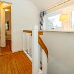 Treppenhaus mit Holzboden und Fenster mit Lampe