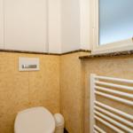 Badezimmer mit Toilette, Heizung und Fenster.