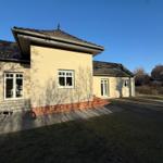 Haus mit Terrasse, Garten und Fenstern. Eine Katze läuft auf dem Hof.