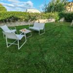 Garden with white seating and green lawn.