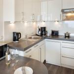 Küche mit Arbeitsplatte, Spüle, Kochfeld und Geräten.