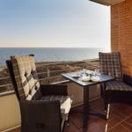 Balkon mit Tisch und zwei Stühlen, Blick auf das Meer.
