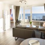 Wohnzimmer mit Blick aufs Meer und Terrasse mit Sitzgelegenheiten.