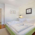 Schlafzimmer mit Bett, Nachttischen und Bildern an der Wand.