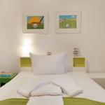 Schlafzimmer mit Bett, Nachttisch und Wandbildern