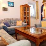 Wohnzimmer mit Sofa, Sessel und Glasplatte Tisch