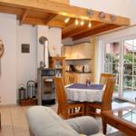 Wohn- und Essbereich mit Holzrahmen, Kamin und Glastüren zum Garten.