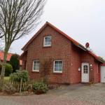 Rotes Backsteingebäude mit weißen Fenstern und Garagenbereich.