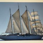 Großes Segelschiff mit mehreren Masten und Segeln auf offener See.