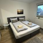 Schlafzimmer mit Doppelbett, Fenster und Kleiderschrank.