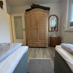Zwei Betten, großer Holzschrank, Fenster und Bodenbelag