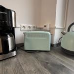 Küchenzeile mit Kaffeemaschine, Toaster und Wasserkocher.