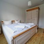 Schlafzimmer mit Doppelbett, Kleiderschrank und Nachttisch.