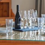 Glasplatte mit Teller, Gläsern und einer Weinflasche.