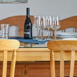 Esstisch mit Stühlen, Weinglas und Weinflasche