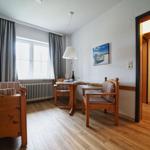 Wohn- und Essbereich mit Holzmöbeln und Blick aus dem Fenster.