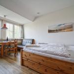 Zimmer mit Bett, Esstisch, Sofa und Fenster mit Blick.