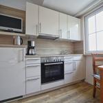 Küche mit weißen Schränken, Herd und Fenster