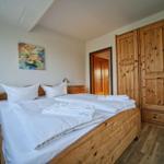 Schlafzimmer mit Holzbett, Kleiderschrank und Nachttisch