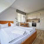 Schlafzimmer mit Doppelbett und integriertem Küchenbereich.