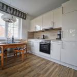 Küche mit Essbereich, Holzboden und Fenster mit Blick nach draußen.