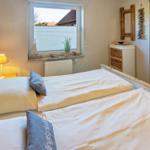 Schlafzimmer mit Doppelbett, Fenster, Schrank und Nachttisch.