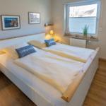 Schlafzimmer mit Doppelbett, Nachttisch und Fenster