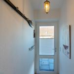 Flur mit Wandgarderobe, Fenster und Wandbild mit Segelboot.