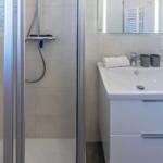 Dusche mit Glaswand, Waschbecken und Spiegel