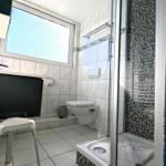 Badezimmer mit Dusche, Toilette und Fenster