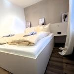 Schlafzimmer mit Bett, Nachttisch und Bildern an der Wand.