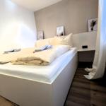 Schlafzimmer mit Bett, Nachttisch und Bildern an der Wand.