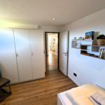 Schlafzimmer mit Bett, Kleiderschrank und Fenster. Anschluss zur Küche.