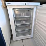 Weißer Kühlschrank mit vier Schubladen und digitaler Anzeige.