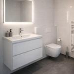 Badezimmer mit Waschbecken, Spiegel und Toilette.