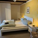 Bedroom with bed, nightstand, and yellow-white striped wall
