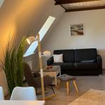 Living room with sofa, stool, and floor lamp under sloped ceiling.
